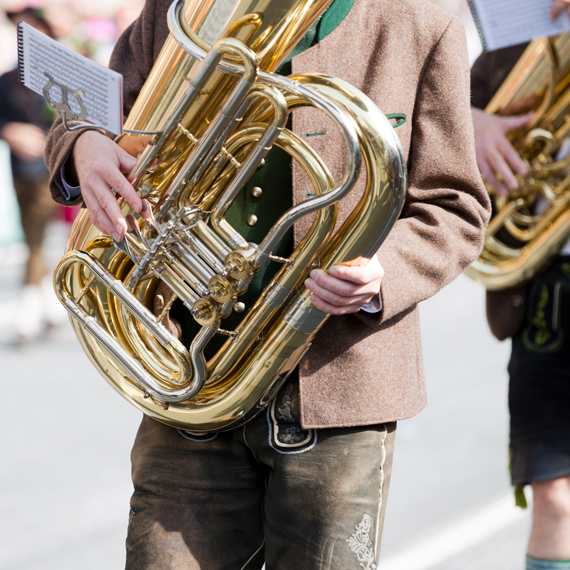 Ein Mann spielt in einer traditionellen bayrischen Tracht auf einer Tuba.