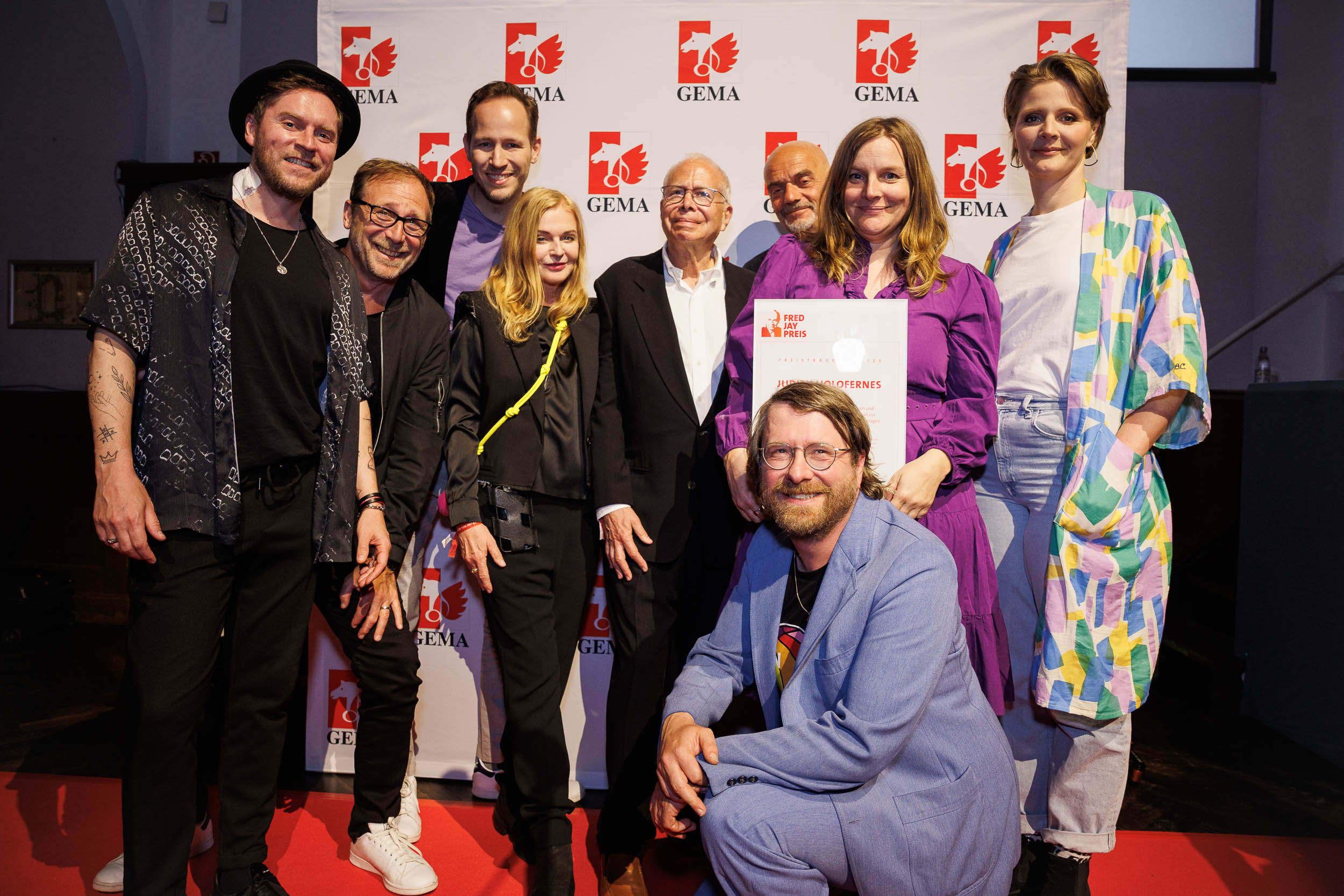 Axel Bosse mit Jury und Stifter auf dem roten Teppich vor einer Pressewand