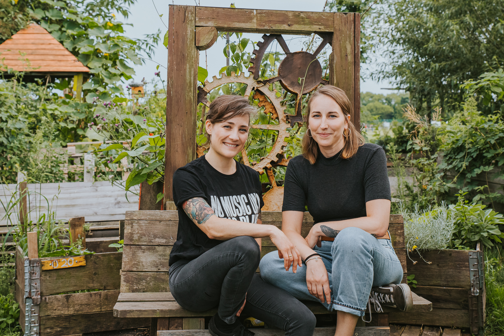 Die Gründerinnen Sarah Lüngen und Katrin Wipper sitzen gemeinsam auf einer Bank.