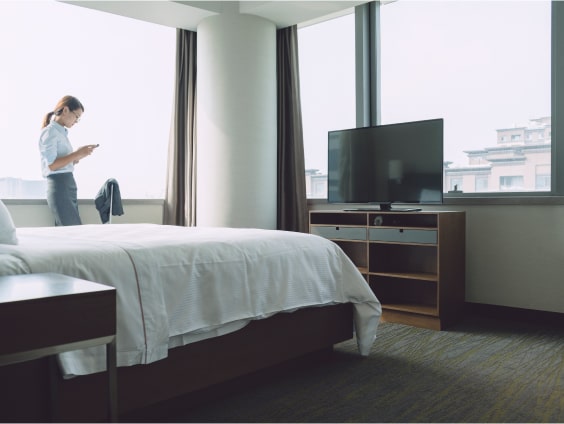 Frau mit Tablet in Hotelzimmer