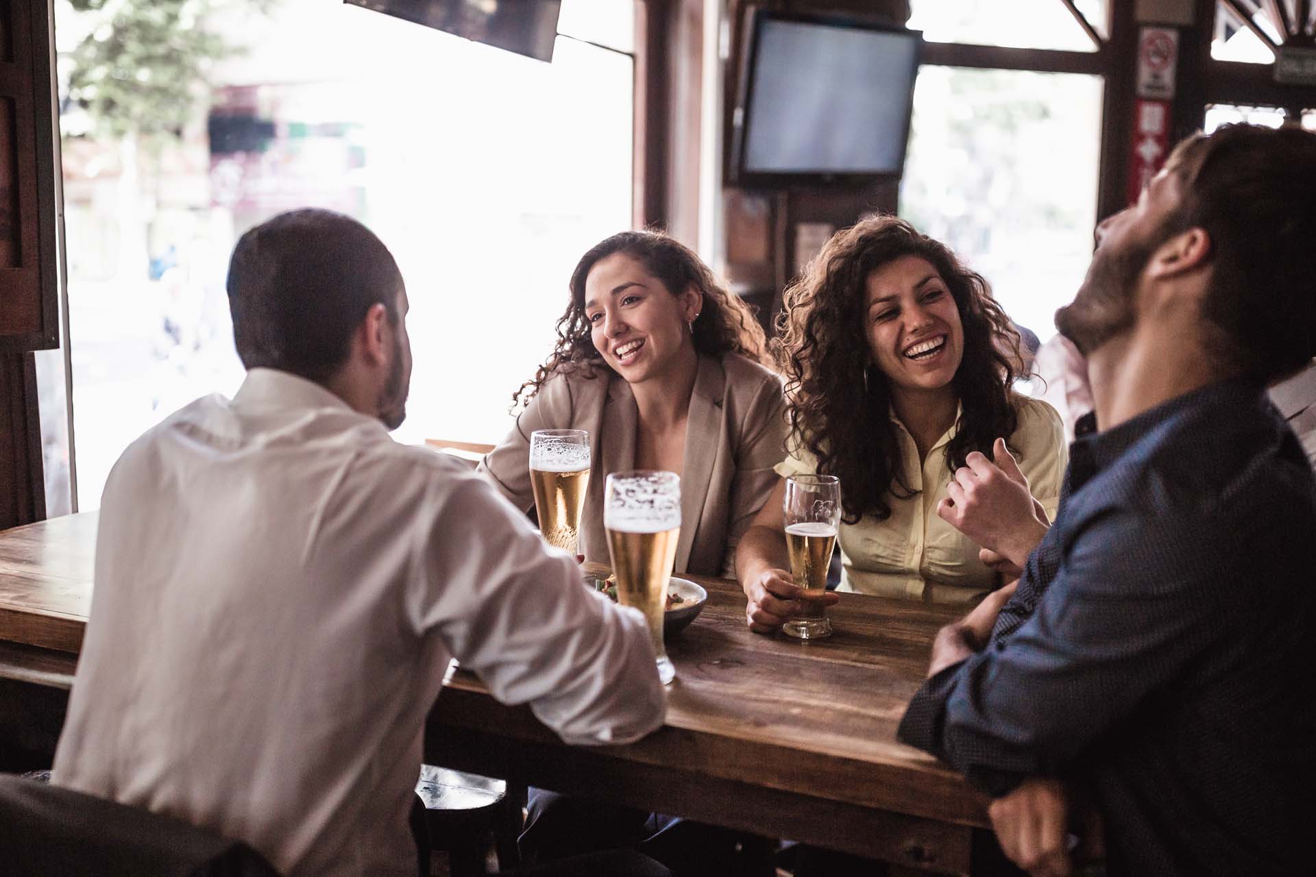 Personen sitzen in der Bar und trinken Getränke