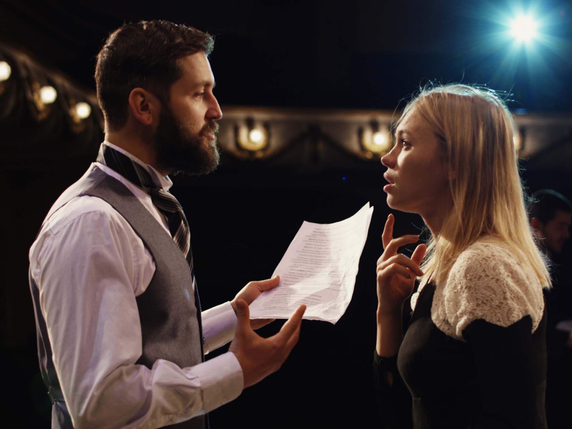 Ein Mann und eine Frau führen auf der Bühne ein Theaterstück auf.