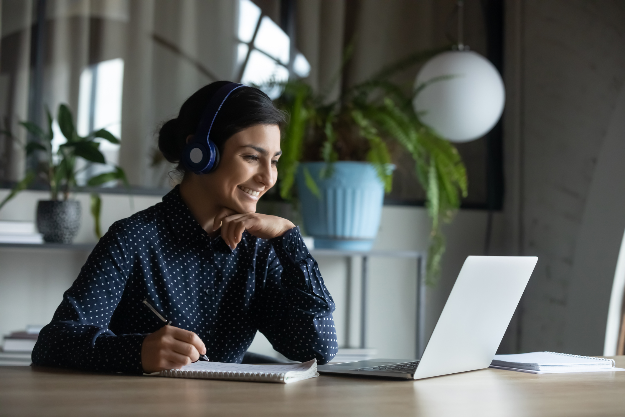 Frau mit Laptop und Headset