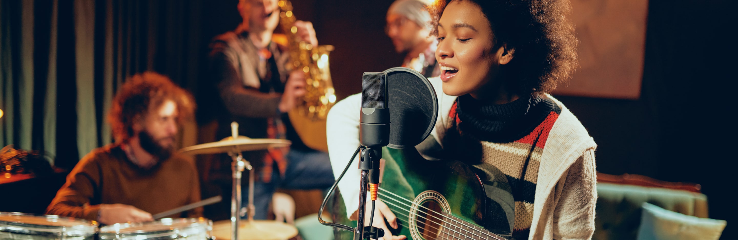 Frau mit Gitarre am Mikrofon