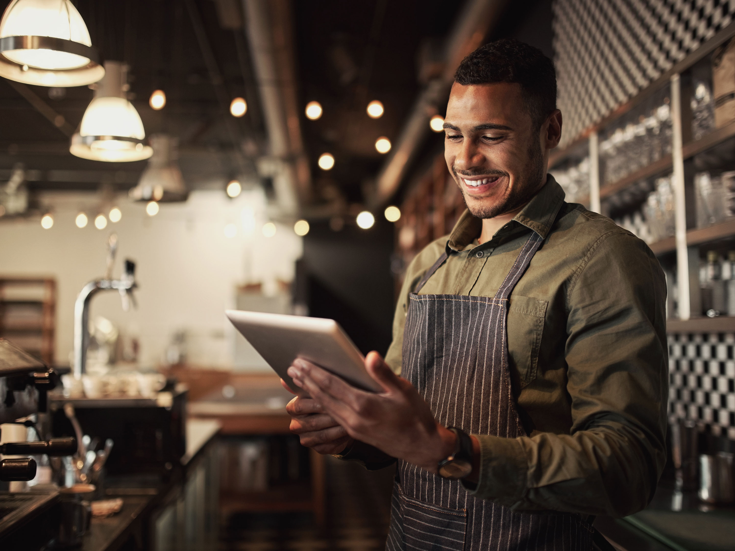 Barista in Kaffeebar mit iPad in der Hand