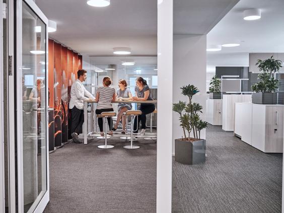 Eine Gruppe von Personen sitzen zusammen im Büro.