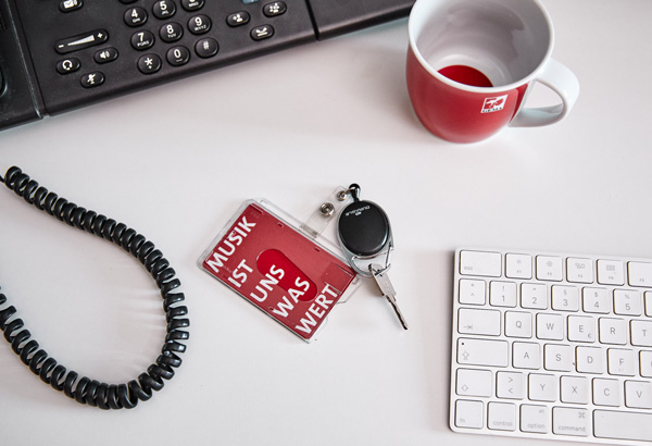 Schreibtisch mit Schlüssel, Tastatur, Tasse und Telefon